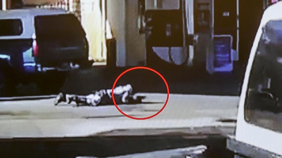In this image made from security video footage provided by the Los Angeles County Sheriff, Nicholas Robertson is stretched out on the ground with a gun in his hand after he was shot by Los Angeles deputies on Saturday, Dec. 12, 2015, in Lynwood, Calif. He died at the scene Saturday morning. Authorities released the video Sunday in response to questions about why they continued to fire on the man after he fell to the pavement.