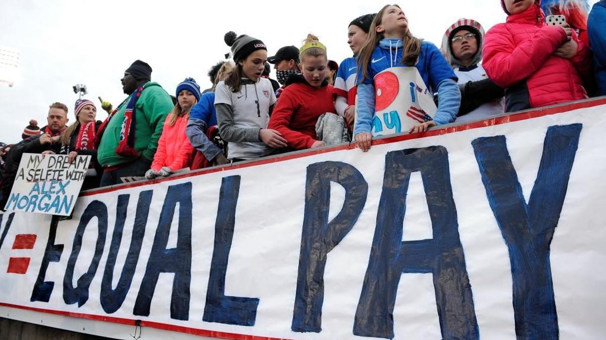 In this April 6, 2016, file photo, fans stand behind a large sign for equal pay for the women's soccer team during an international friendly soccer match between the United States and Colombia. The World Economic Forum's annual Global Gender Gap Report released on Oct. 25, 2016, found that the global gender pay gap will not be closed for another 170 years if current trends continue.