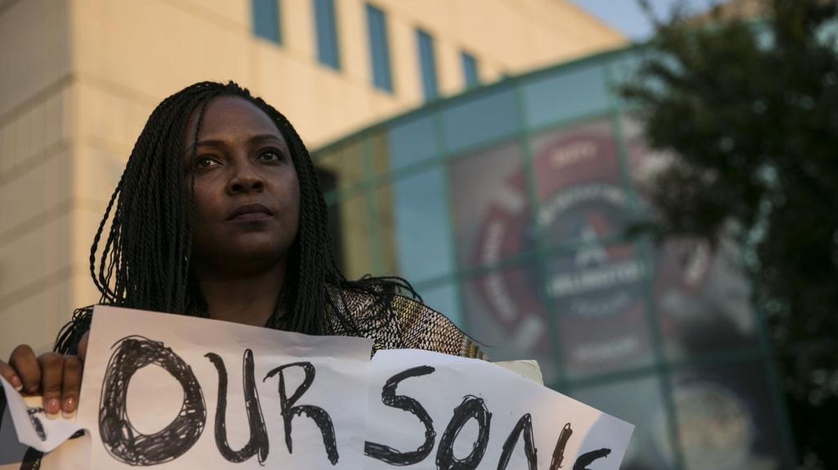 
Denise Hamilton holds a sign protesting Christian Taylor's death outside the Arlington Police Department on Tuesday.
