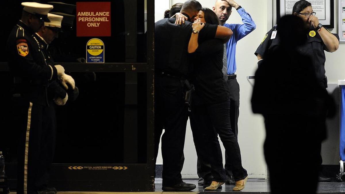 Peace officers lend each other support at Desert Regional Medical Center in Palm Springs on Saturday, Oct. 8, 2016. Two Palm Springs police officers trying to resolve a family dispute were killed Saturday when a man they had been speaking with suddenly pulled out a gun and opened fire on them, the city's police chief said. A third officer was wounded and remained hospitalized. The shooter was not immediately identified.