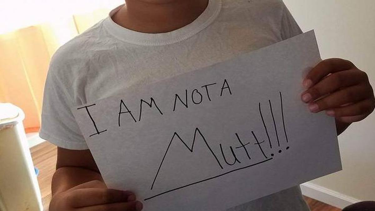 Kevin Brown took a photo of his biracial son holding up a sign reading, “I am not a mutt!!!” after his son reported hearing a teacher use the term to describe him.