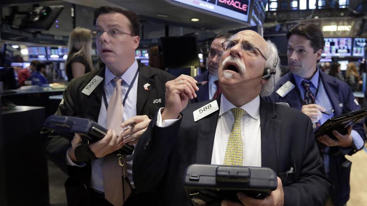 
Peter Tuchman, foreground right, works with fellow traders on the floor of the New York Stock Exchange, Monday, Aug. 24, 2015. 
