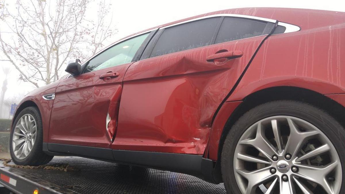 A damaged car sits on a tow truck Friday morning, January 8, 2016, near a northeast Fresno ATM where a violent confrontation happened. Police say would-be bandits struck this vehicle with a getaway car. The vehicle’s owner, a retired police officer, fired shots at the getaway car, wounding the driver.