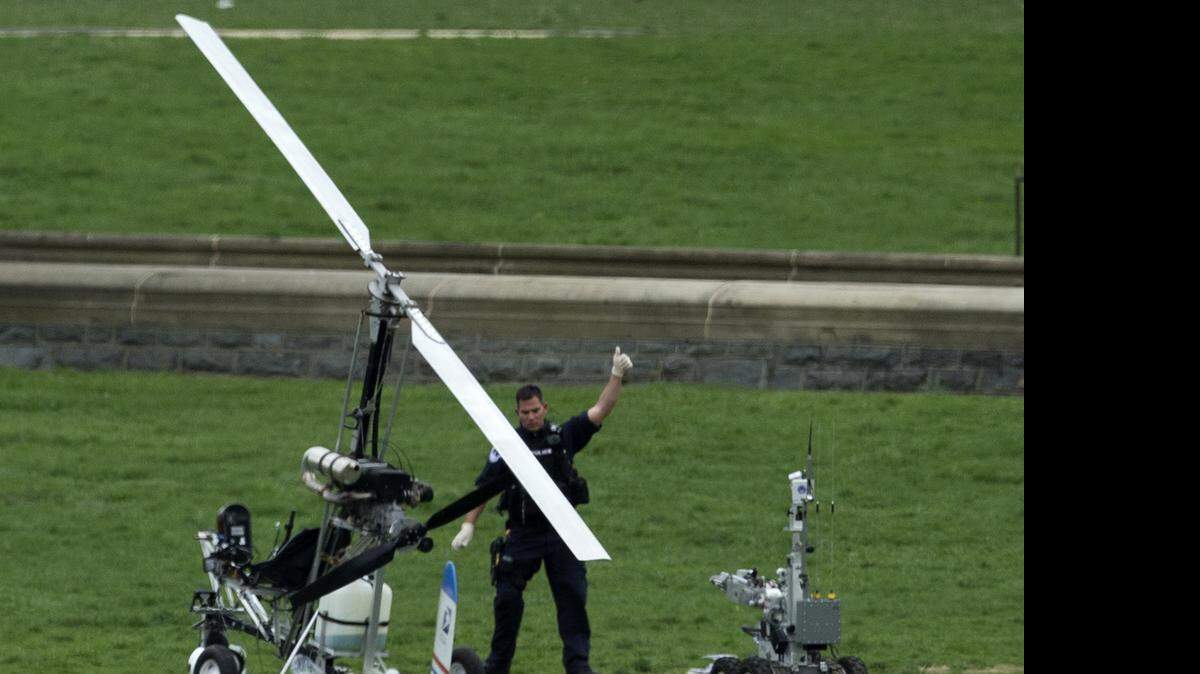 
A Capitol Police officer flashes a thumbs up after inspecting the small helicopter a man landed on the West Lawn of the Capitol in Washington, Wednesday, April 15, 2015. 
