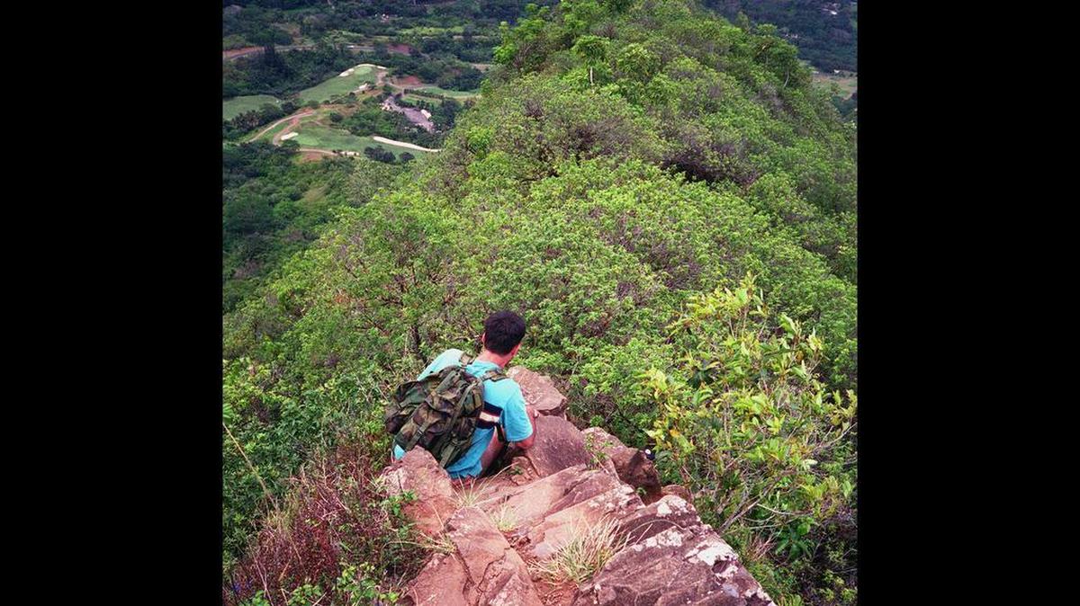 A man sits on a rock along the Olomana Trail in Oahu, Hawaii, in this April 2001 photo. The hike is is maintained but dangerous, and several people have died while hiking it in recent years. (AP Photo/Charles S. Rice)