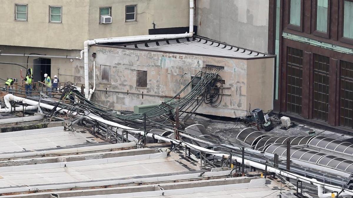 Workers inspect damage on a section of the roof of the Hoboken station as seen from Jersey City, N.J., Thursday, Sept. 29, 2016. A crowded commuter train plowed into the bustling station during the morning rush hour Thursday, injuring more than 100 in a tangle of broken concrete, twisted metal and dangling cables, authorities said.