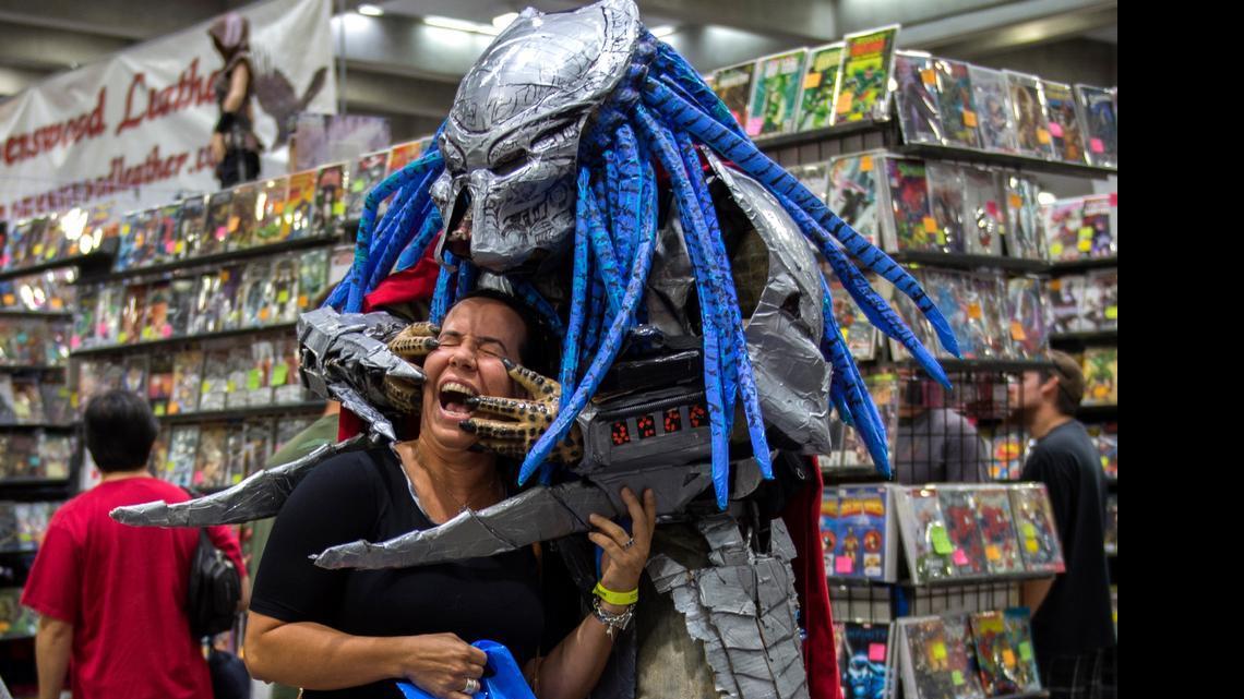 
Dressed as the Predator, Daniel Lozano appears to find his prey as he clowns around with Katrina Mitchell of Davis at Wizard World Comic Con on Sunday. “I’m a celebrity here when I dress up in big costumes,” said Lozano, 35, of Sacramento. 
