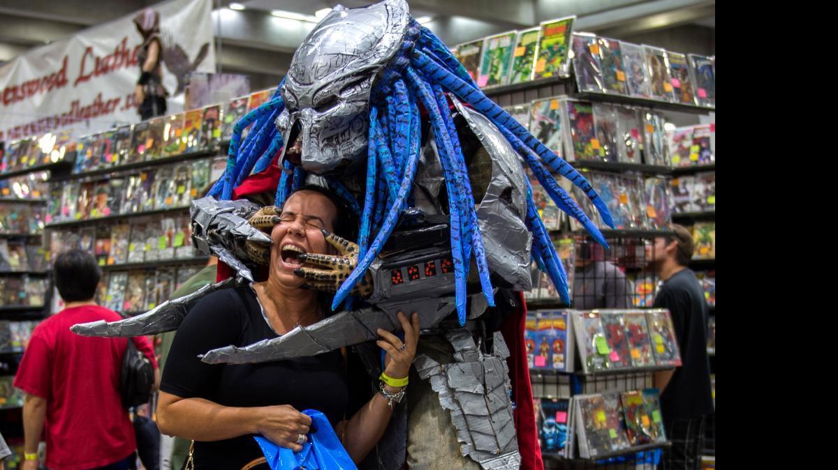 
Dressed as the Predator, Daniel Lozano appears to find his prey as he clowns around with Katrina Mitchell of Davis at Wizard World Comic Con on Sunday. “I’m a celebrity here when I dress up in big costumes,” said Lozano, 35, of Sacramento. 
