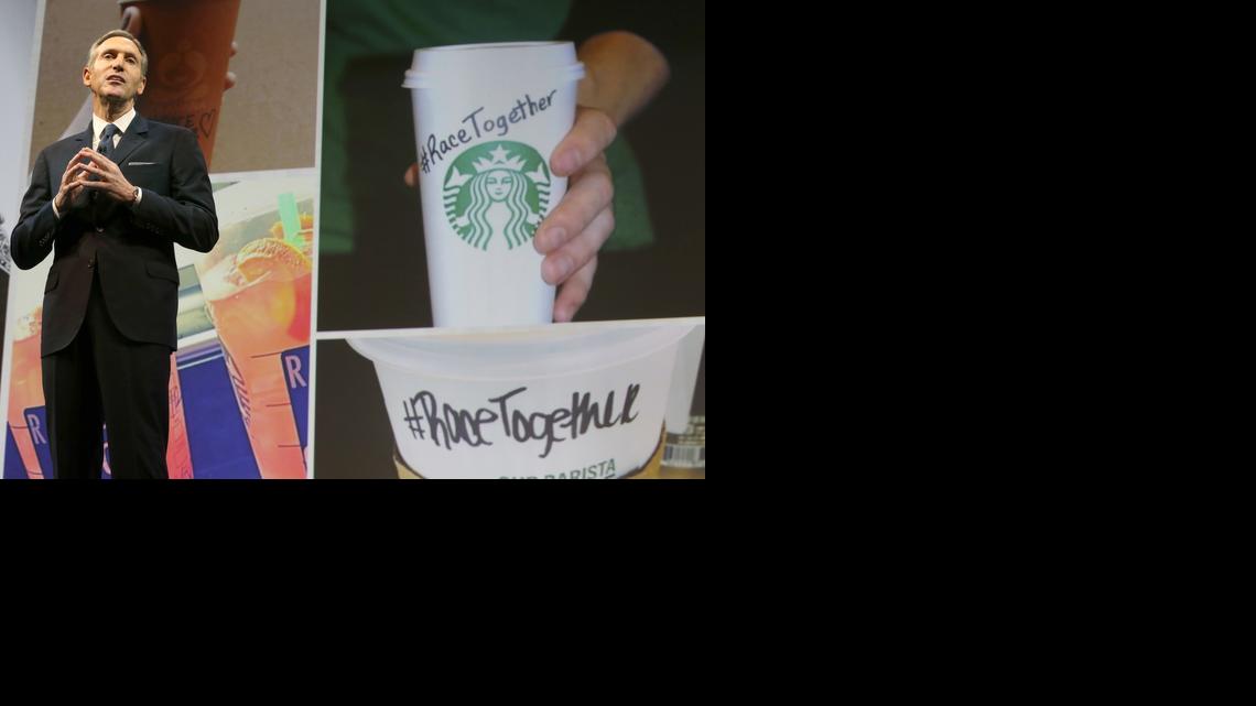 
Starbucks CEO Howard Schultz speaks Wednesday, March 18, 2015, at the coffee company’s annual shareholders meeting in Seattle. To the right is a photo of a coffee cup with #RaceTogether written on it, part of a new company campaign. 
