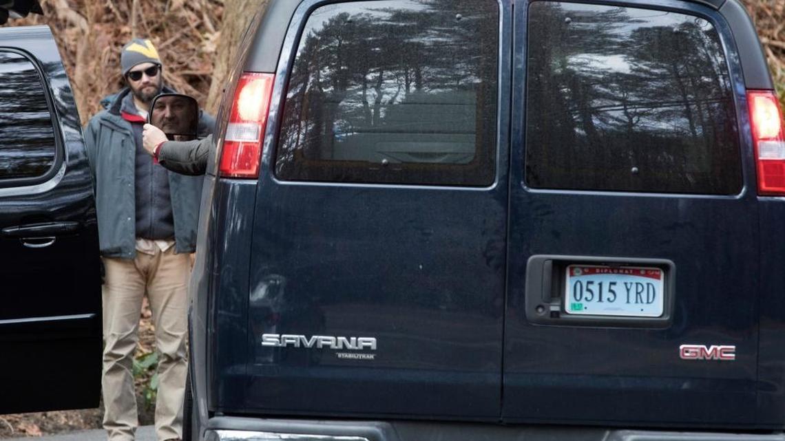 A man driving a van with diplomatic license plates hands his identification to U.S. special agents outside an estate in the town of Oyster Bay, N.Y., on Long Island on Friday. The compound was one of two the U.S. government closed to Russian diplomats in retaliation for what the Obama administration has said was cyber-meddling in the U.S. presidential election.