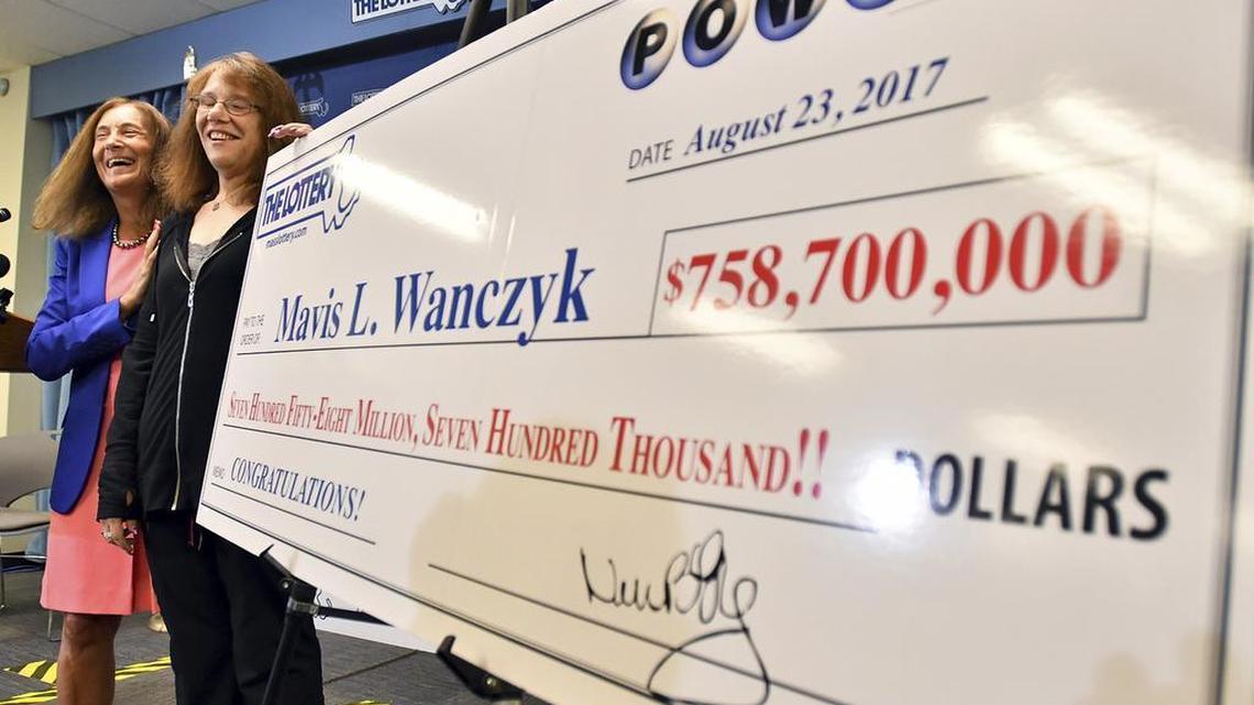 Mavis Wanczyk, of Chicopee, Mass., stands by a poster of her winnings during a news conference where she claimed the $758.7 million Powerball prize at Massachusetts State Lottery headquarters, Thursday, Aug. 24, 2017, in Braintree, Mass. Officials said it is the largest single-ticket Powerball prize in U.S. history.
