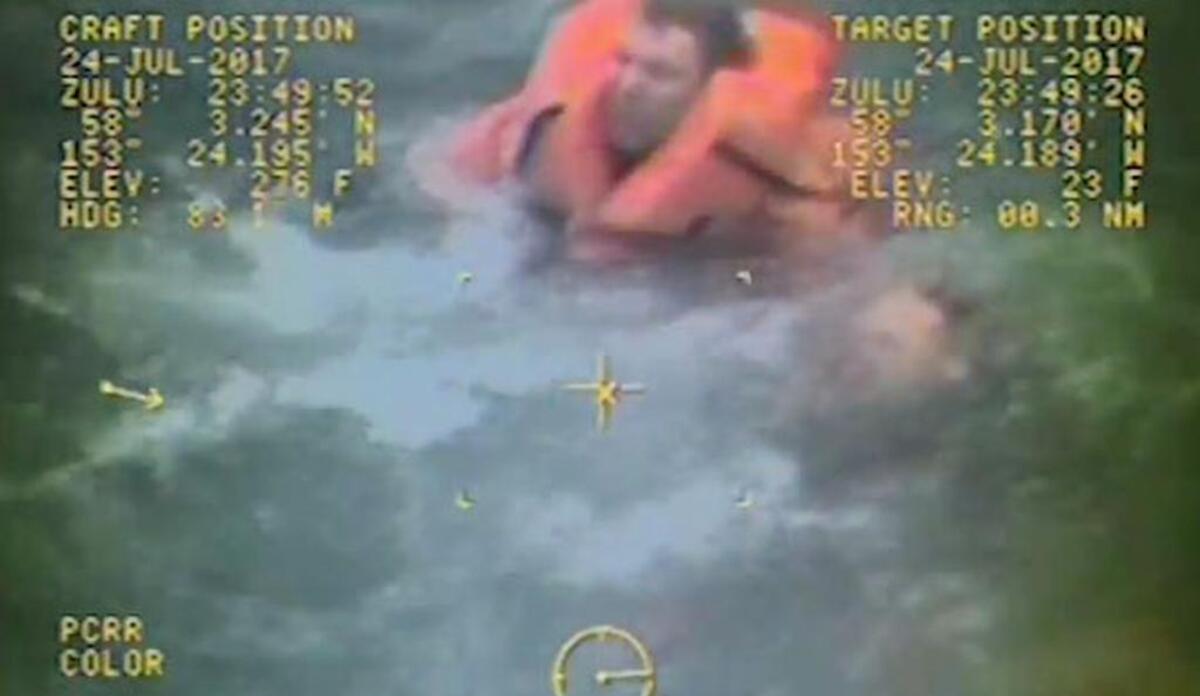 Footage from the Coast Guard video shows Trosvig with an orange life jacket strapped to his shoulders paddling up to the fisherman and grabbing hold of him by his right arm.
