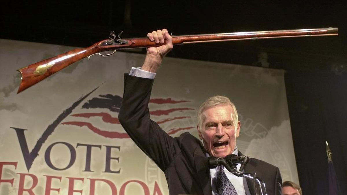 
National Rifle Association President Charlton Heston holds up a rifle as he addresses gun owners during a “get-out-the-vote” rally in Manchester, N.H., in October 2002. Gun interests, wary of any possible limits on weaponry, have successfully lobbied for limitations on government research and funding into the causes of gun violence, and which policies work best against it.
