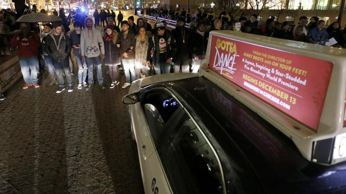 Protesters block rush hour traffic along the Michigan Avenue bridge over the Chicago River Nov. 25, 2015, in Chicago, the day after murder charges were brought against police officer Jason Van Dyke in the killing of 17-year-old Laquan McDonald.