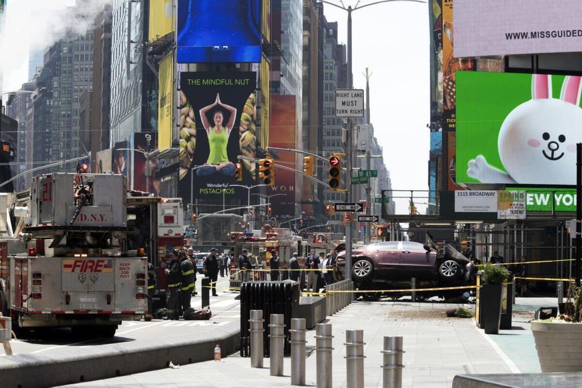 A car rests on a security barrier in New York’s Times Square after driving through a crowd of pedestrians, injuring at least a dozen people, Thursday, May 18, 2017.