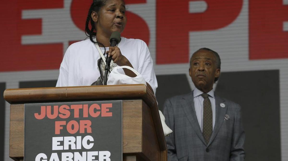 
Eric Garner’s wife, Esaw Snipes, is joined by the Rev. Al Sharpton as she speaks on stage during a rally in New York on Saturday, July 18, 2015. Several hundred people rallied outside the federal courthouse in Brooklyn to demand action in the fatal chokehold death of Garner by a white police officer. 
