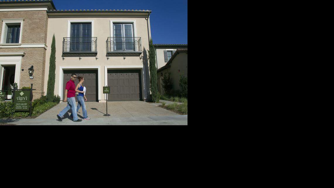 Rafael Lopez, left, and his wife, Jacqueline, step out of a model home at Trevi and Amelia luxury homes on Nov. 21, 2014, in the Orchard Hills community in Irvine, Calif. President Barack Obama moved Wednesday to make it cheaper for first-time and younger buyers to take out a mortgage.