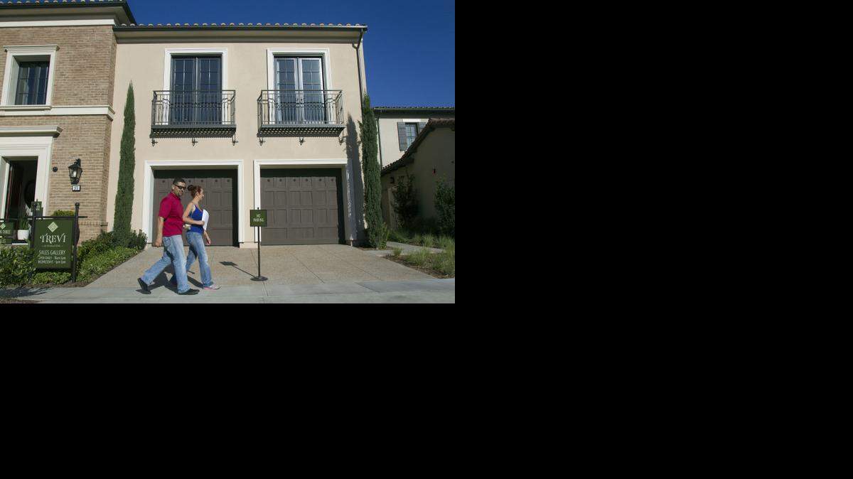 Rafael Lopez, left, and his wife, Jacqueline, step out of a model home at Trevi and Amelia luxury homes on Nov. 21, 2014, in the Orchard Hills community in Irvine, Calif. President Barack Obama moved Wednesday to make it cheaper for first-time and younger buyers to take out a mortgage.