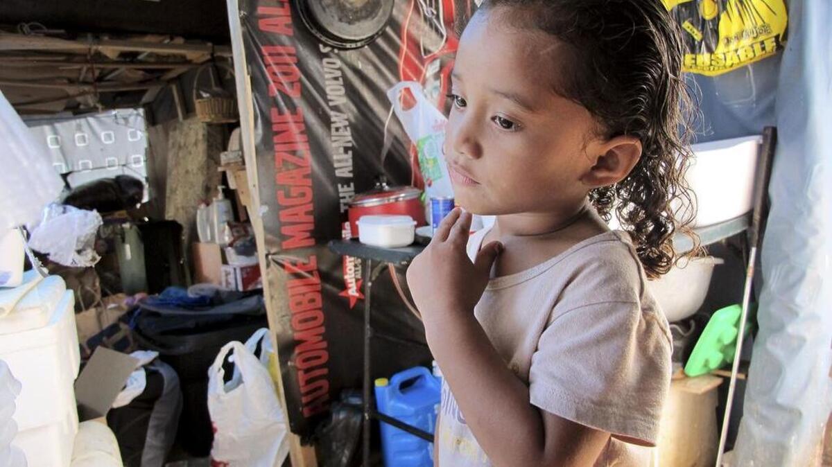 Keioleen Helly, 3, stands inside her family’s sidewalk shelter in Honolulu in October 2015. The family was packing up belongings to take to a storage unit two days before the city planned to clear their block of the homeless encampment, hoping to get a ride to the storage unit from a volunteer.