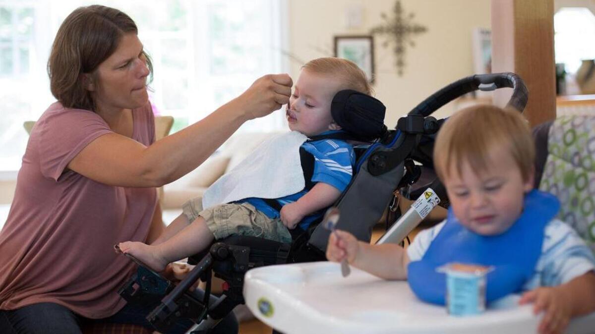 Erica Mumm feeds her son Christian, who has severe epilepsy, as his fraternal twin, Connor, feeds himself at their home in New Hartford, Connecticut. GlaxoSmithKline has promised to help the Mumms get the drug Christian needs despite its withdrawal from the market.