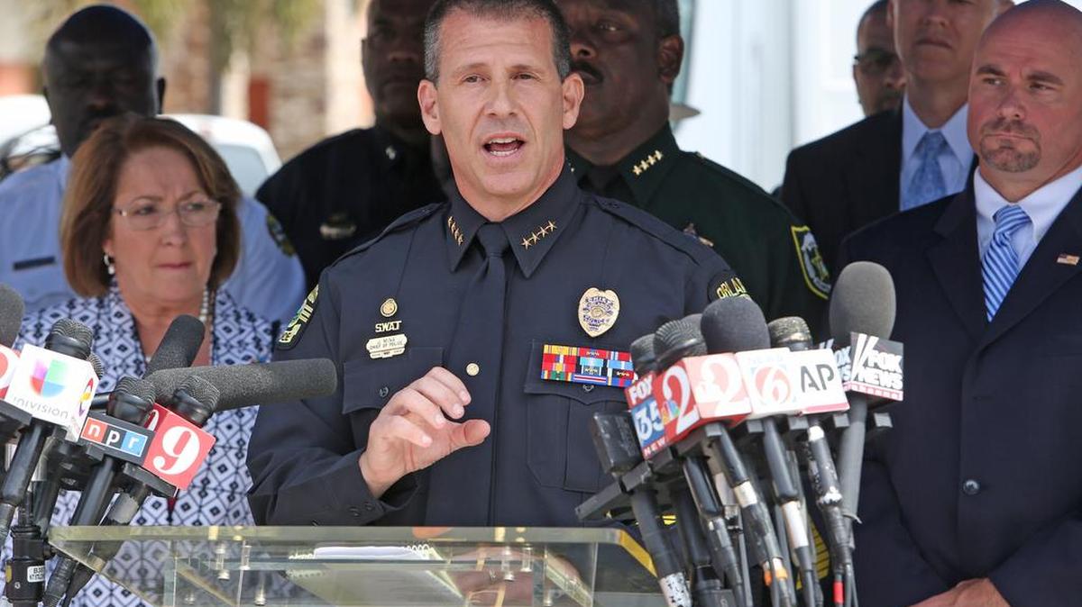 Orlando Police Chief John Mina, center, talks to the media during a press briefing near the Pulse Nightclub shooting scene in Orlando, Fla.