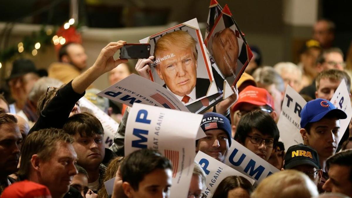Audience members hold signs to be autographed by Republican presidential candidate Donald Trump during a campaign rally at the Veterans Memorial Building in Cedar Rapids, Iowa.