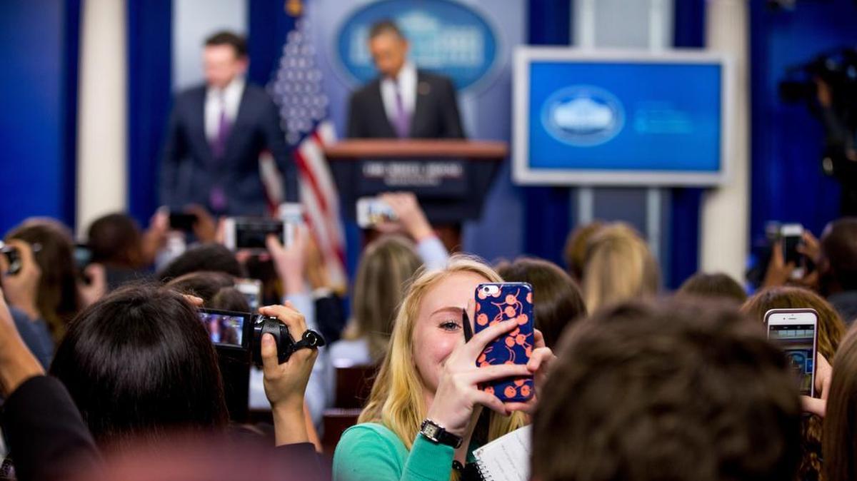A college student takes a selfie as President Barack Obama, background center, with White House press secretary Josh Earnest, surprises college students participating in a mock daily press briefing for reporter day, April 28 at the White House. When and how is it appropriate to ask a celebrity (or president) for a selfie?