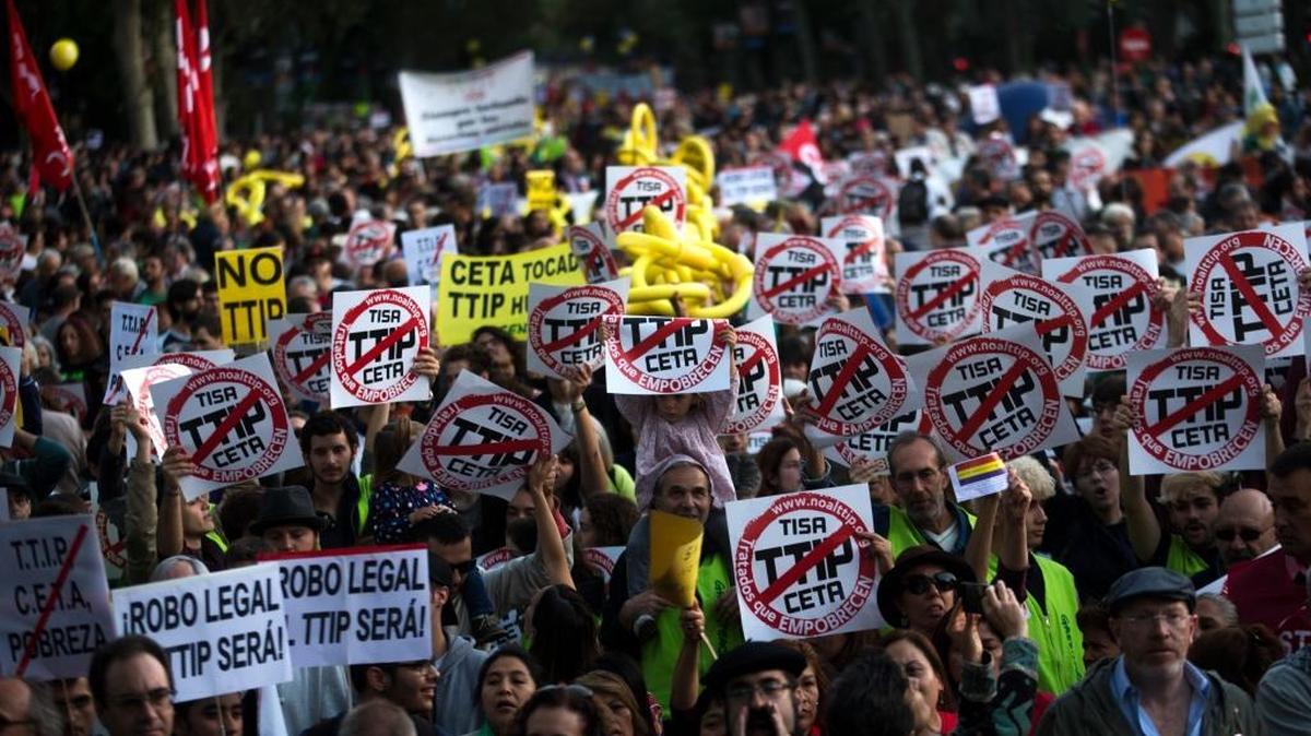 People holding up posters against the proposed Trans-Atlantic Trade and Investment Partnership march during a protest in Madrid, Saturday, Oct. 15, 2016. Several hundred people have gathered in Madrid to protest the major free trade deal between the United States and the European Union.