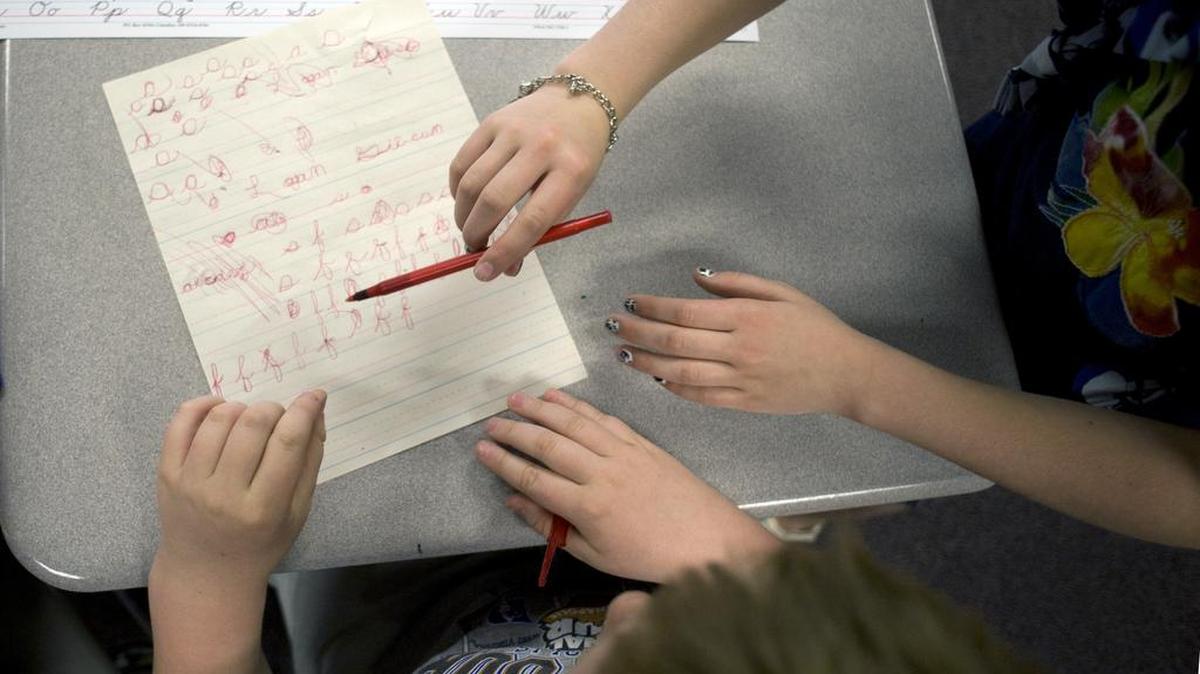 Then-third-grader Logan Gibson receives help from a classmate while learning the cursive alphabet at White Lick Elementary School in Brownsburg, Ind., on April 22, 2011. The reading and writing of cursive has become less common to a growing number of young people as many school districts are spending far less time teaching it. Lawmakers in Washington state are considering a bill that would make the instruction of cursive writing mandatory in all schools.