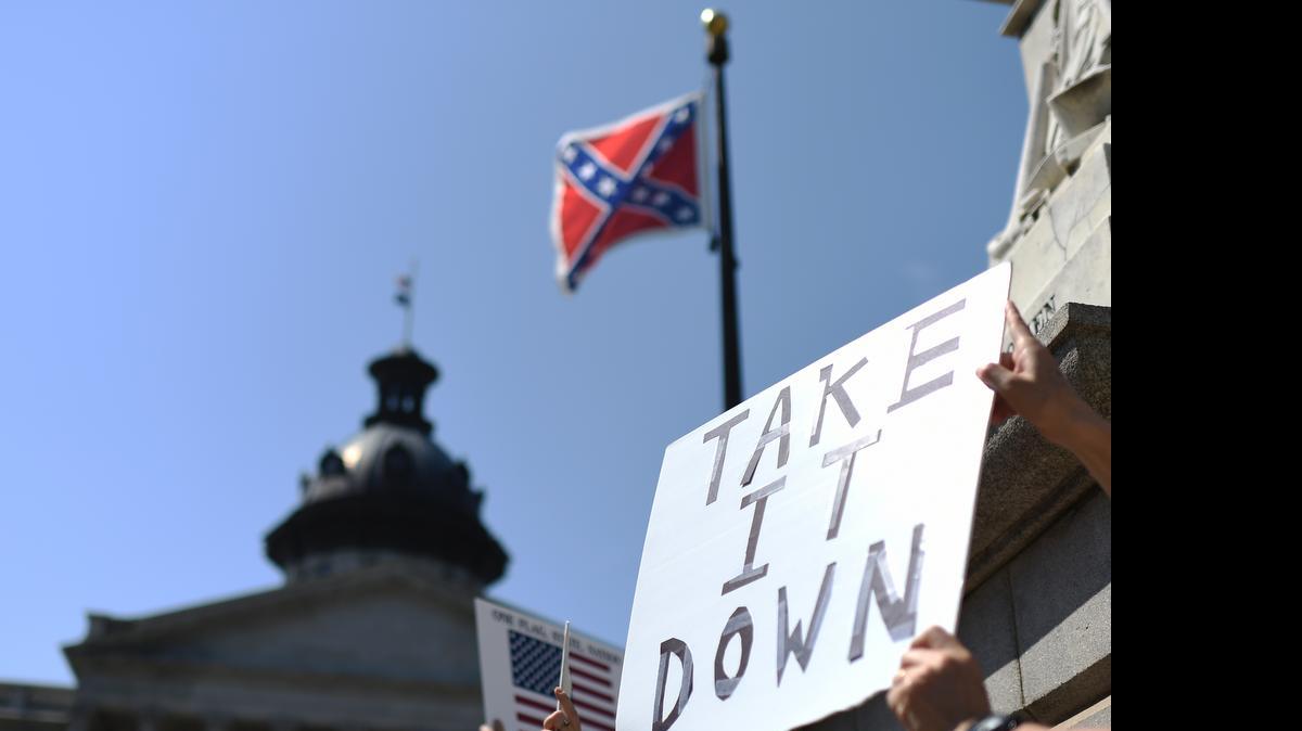 
Protesters hold a sign during a rally to take down the Confederate flag at the South Carolina Statehouse on June 23 in Columbia, S.C. For years, South Carolina lawmakers refused to revisit the Confederate flag on Statehouse grounds, saying the law that took it off the dome was a bipartisan compromise, and renewing the debate would unnecessarily expose divisive wounds. Now, with the debate reignited by the shooting of nine black people at a Charleston, S.C., church, a survey indicates that a supermajority of legislators would vote to take the flag down.
