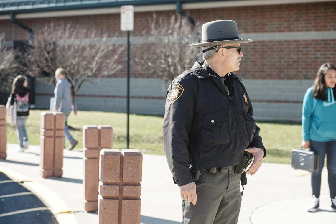 Rick Cron, a school resource officer with the Shelby County Sheriff's Office, watches students and the parking lot during dismissal in Sidney, Ohio.