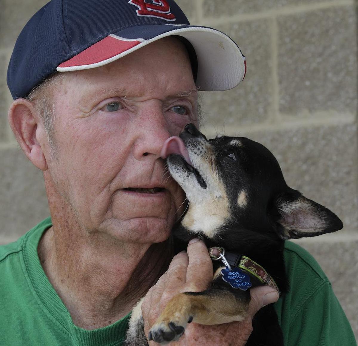 Jim Wilkerson, standing in front of Tom’s Market in Freeburg, need only ask for a kiss and his 12-year-old miniature pinscher, Lucky, will lick his face with his tiny tongue.