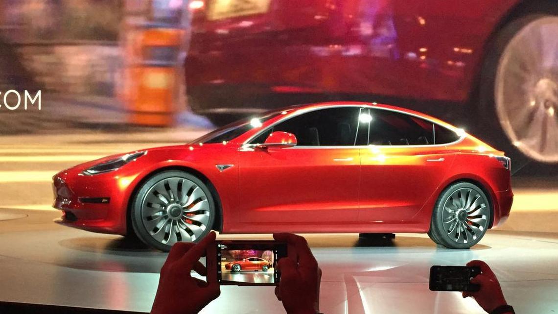 Tesla Motors unveils the new lower-priced Model 3 sedan in March at the Tesla Motors design studio in Hawthorne, Calif.