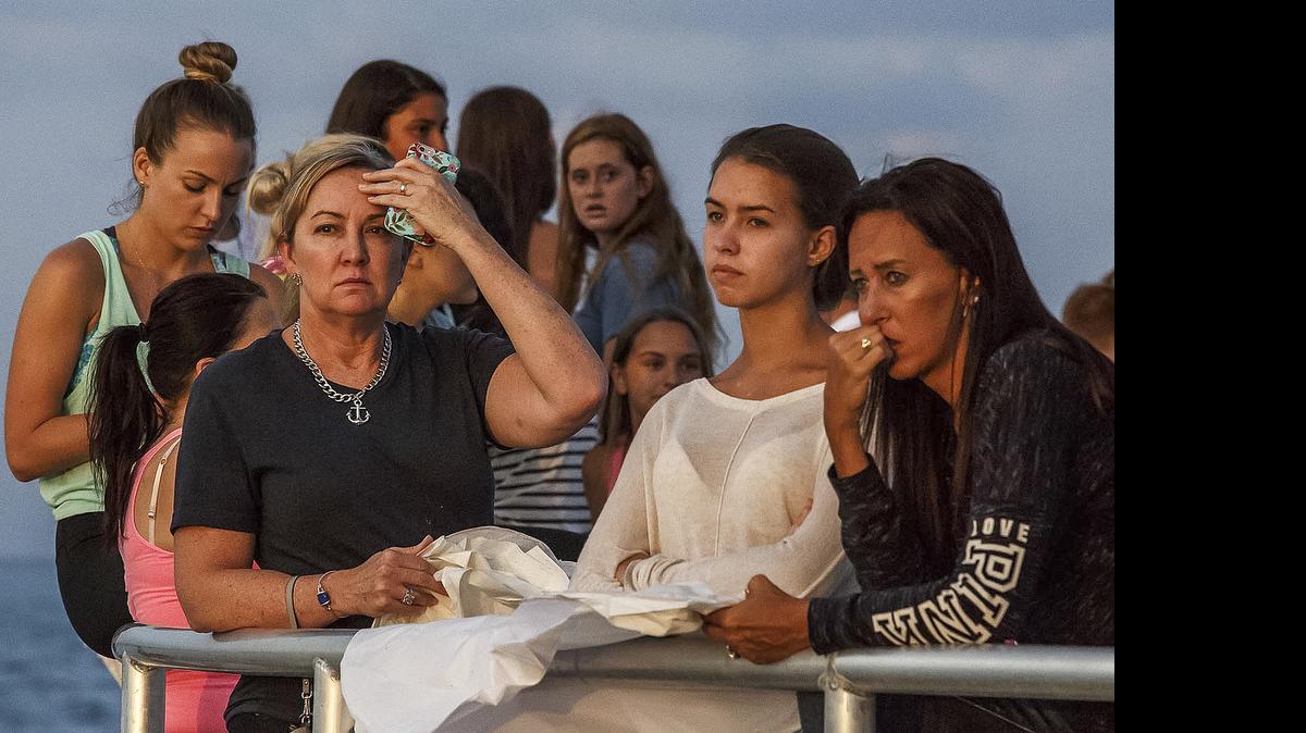
People gather during a candlelight vigil and paper balloon release at Jupiter Inlet Park, Monday, July 27, 2015, for teenagers Austin Stephanos and Perry Cohen in Jupiter, Fla. The teens were last seen Friday afternoon buying fuel near Jupiter and were believed to have been heading toward the Bahamas. 
