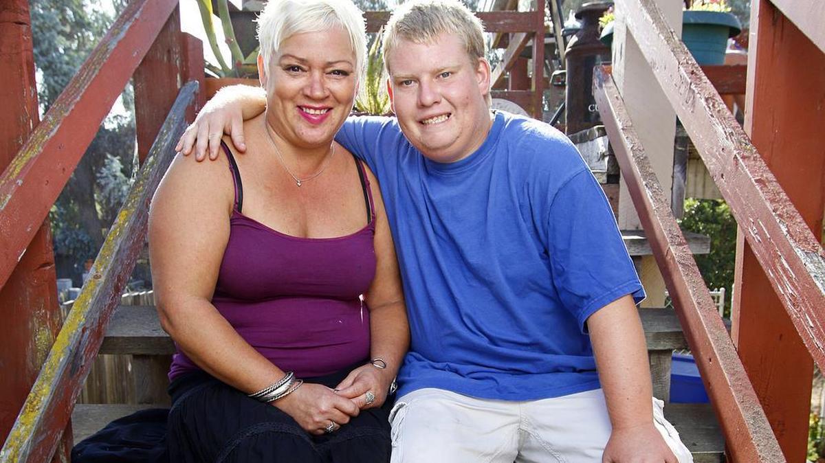 Tyler Jarvis, who has Prader-Willi Syndrome, sits with his mom, Michelle Christian, at their Pismo Beach home.