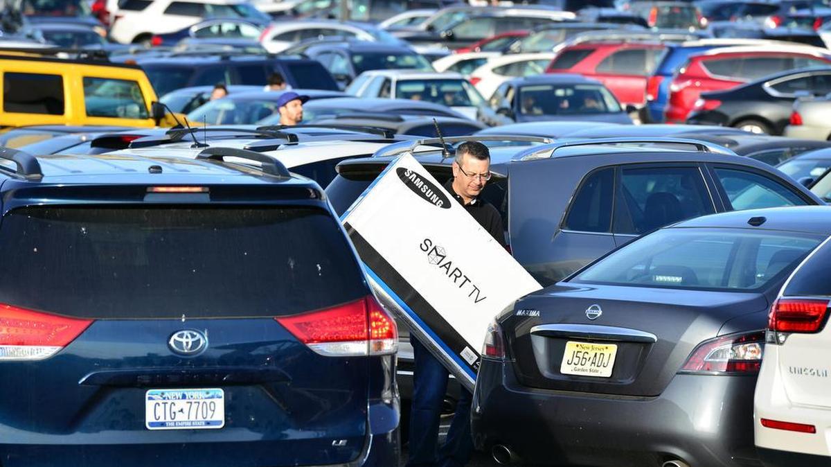A man carries a television at Garden State Plaza Mall, Nov. 27, 2015, in Paramus, N.J.