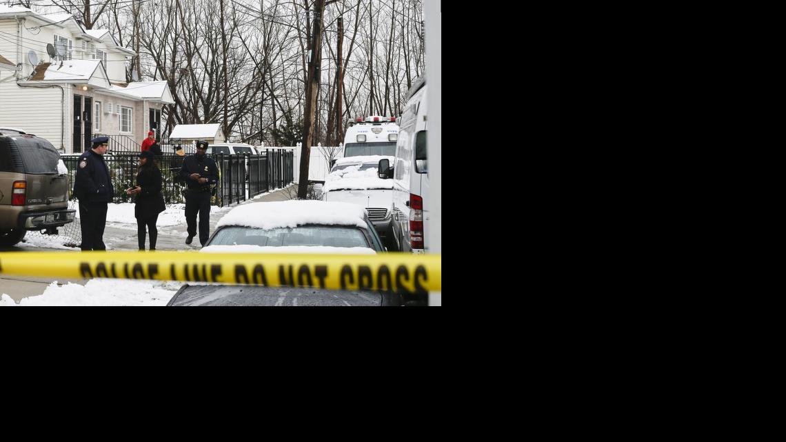 
Police gather near a home located at 231-11 148th Avenue, left, Saturday, Jan. 24, 2015, in the Queens borough of New York. Police say a father shot his daughters, his girlfriend and her mother in their home and then killed himself after the shooting that left three generations of women dead and a 12-year-old critically injured. 
