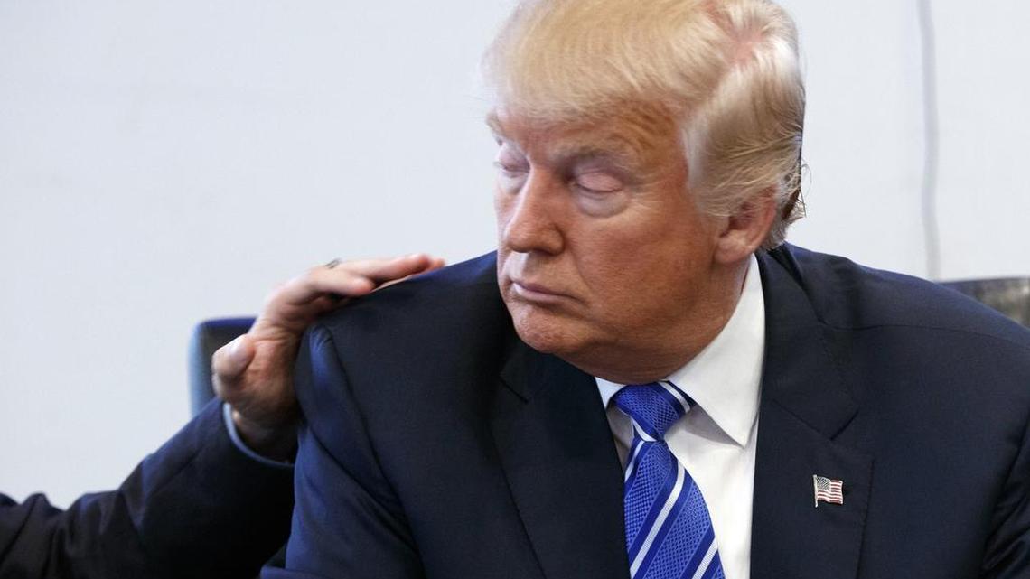 Art Del Cueto, a vice president for the National Border Patrol Council, puts his hand on the shoulder of Republican presidential candidate Donald Trump during a meeting at Trump Tower, Friday, Oct. 7, 2016, in New York.