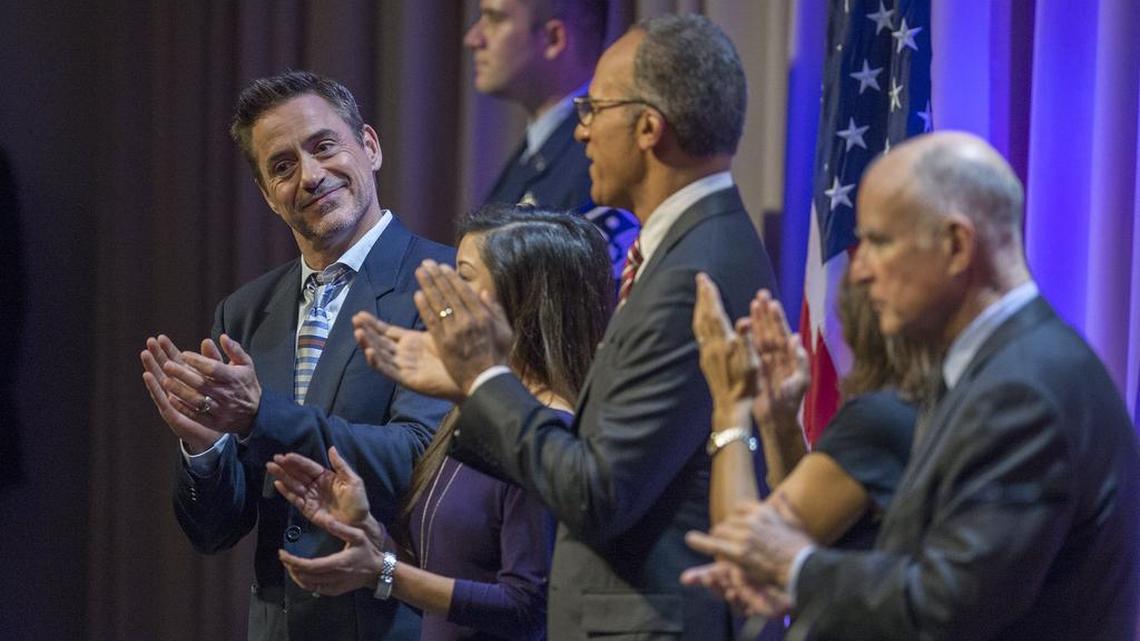 Robert Downey Jr., left, is introduced at the 9th Annual California Hall of Fame induction ceremonies at the California Museum in Sacramento, Calif. on Oct. 28, 2015. Gov. Jerry Brown is at right.