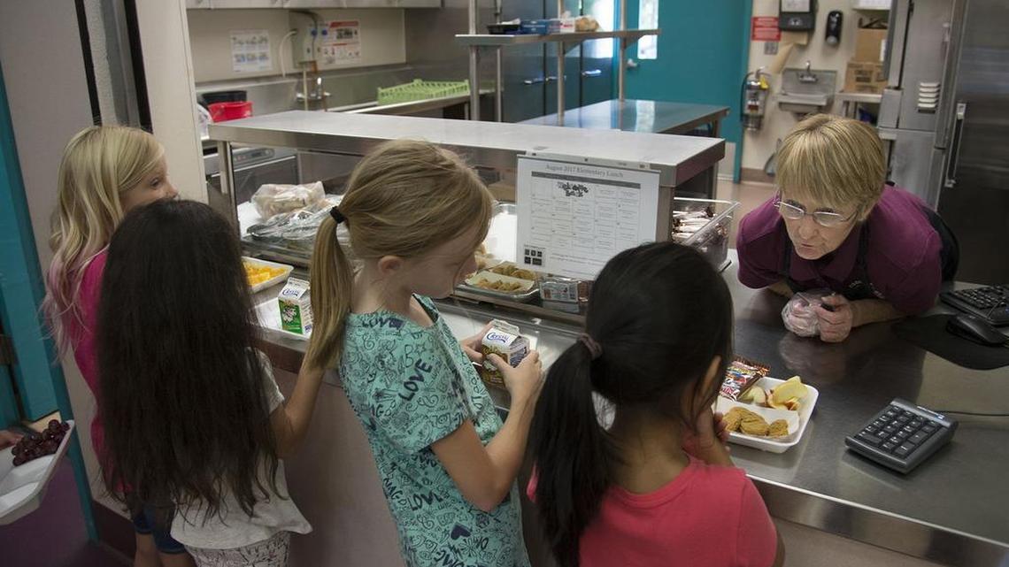 Students get their lunch from food service worker Karen Ynigues at Natoma Station Elementary School on Tuesday, August 15, 2017 in Folsom, Calif.