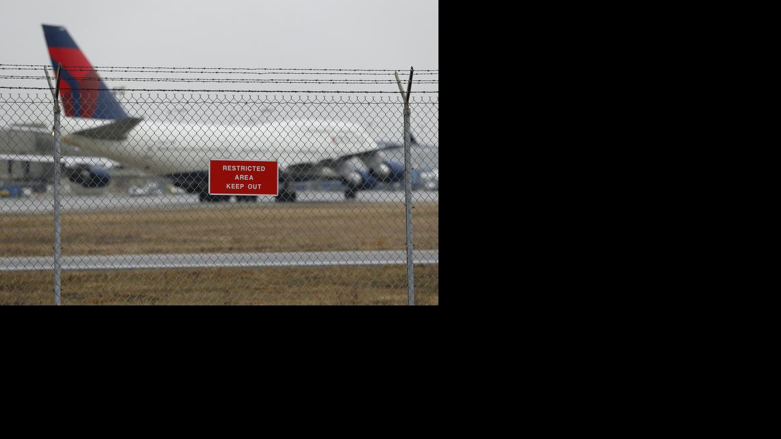 
A sign is shown posted on a perimeter fence near Delta 747 aircraft taxiing at the Detroit Metropolitan Airport in Romulus, Mich., Thursday, April 9, 2015. The security fences and perimeter gates at Detroit Metropolitan Airport have been breached four times in the past two years, an Associated Press investigation shows. Nationally, at least 268 such breaches occurred at 31 major U.S. airports since the start of 2004. 
