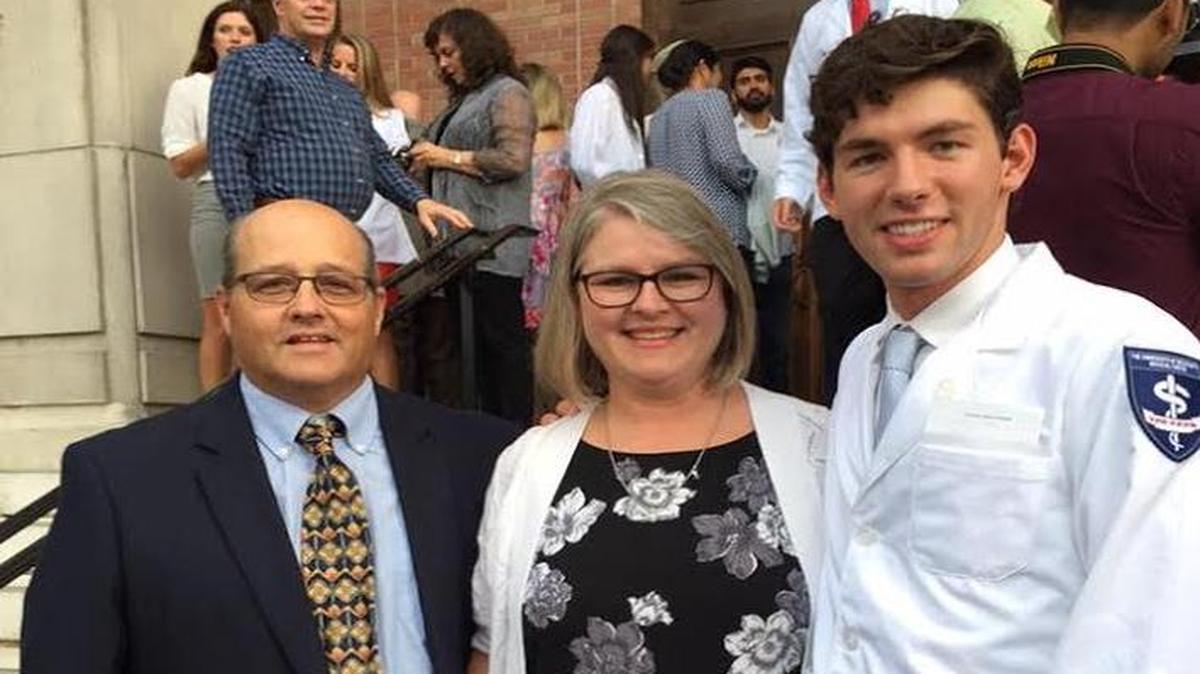Andrew Strachan was joined at his white coat ceremony, marking his entry into medical school, by foster parents Roddy and Lucy Russell of Gulfport, whom he now calls mom and dad.