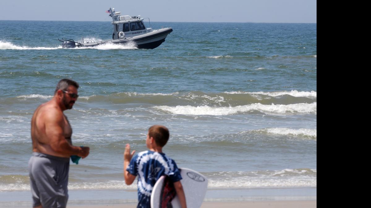 
Jack Cross, 9, watches as a boat patrols the coastline near Ocean Crest Pier in Oak Island, N.C., on Monday.

