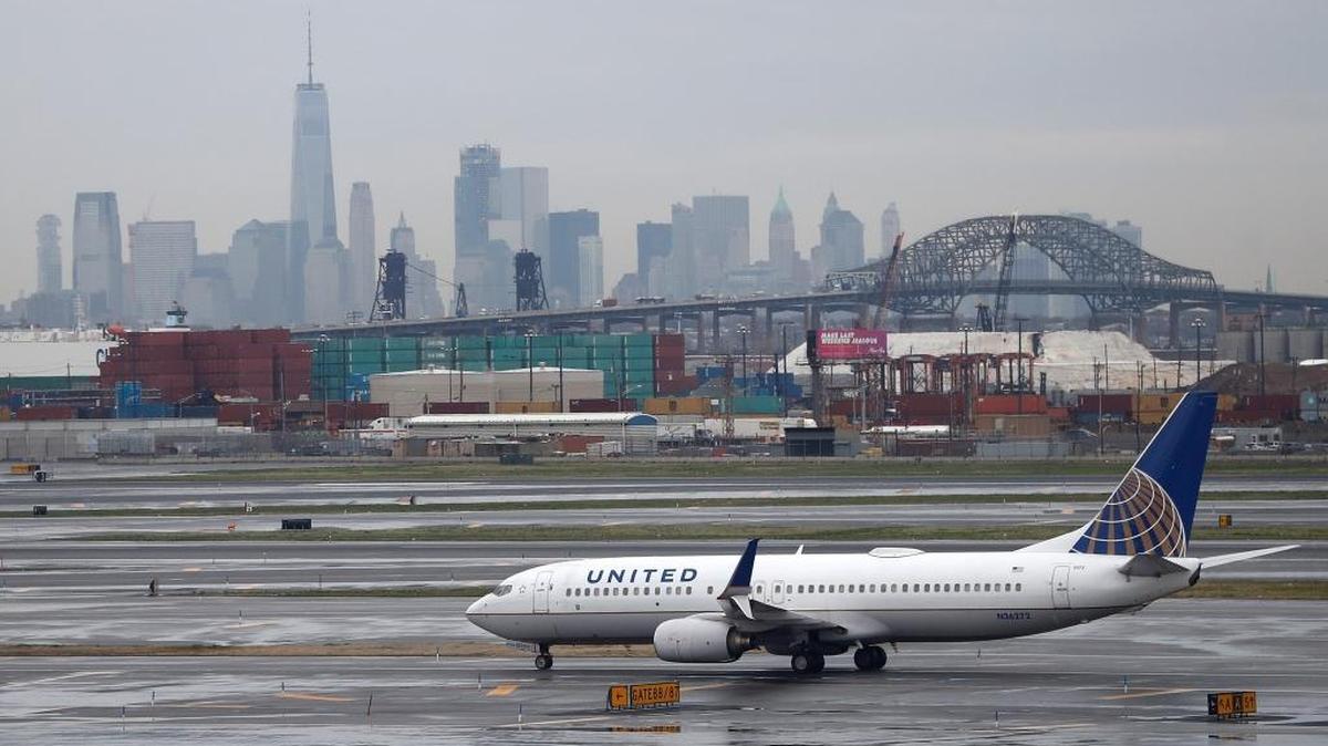 The New York skyline looms in the background as a United Airlines plane taxis at Newark Liberty International Airport on Wednesday, April 12, 2017, in Newark, N.J.
