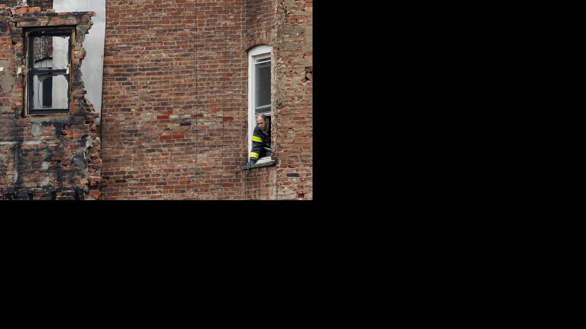 
A fire official stands at the window of a building adjacent to the site of a building collapse in the East Village neighborhood of New York, Friday, March 27, 2015. 
