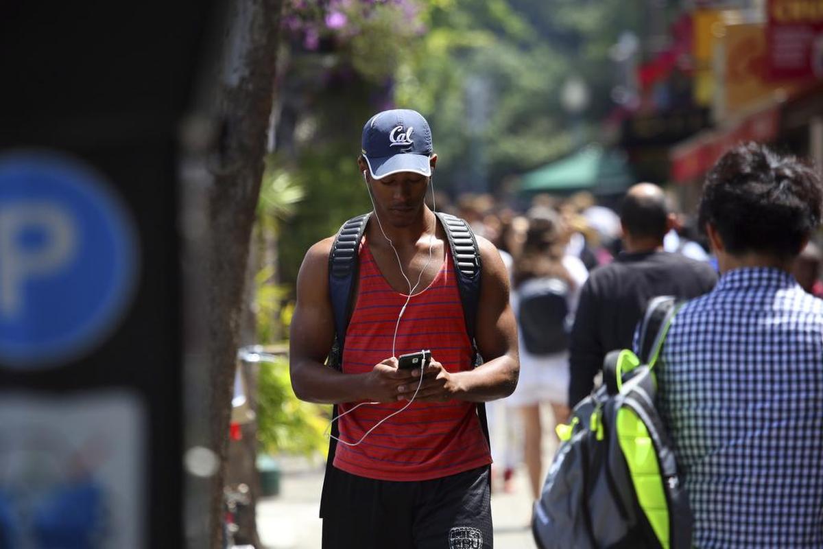 A cellphone user walks near the campus of the University of California, Berkeley, in July. Authorities say a man distracted by a cell phone or camera fell to his death from a San Diego cliff on Christmas Day.