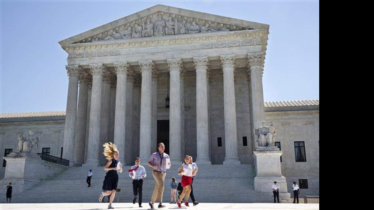 New interns run with a decision across the plaza of the Supreme Court in Washington, Monday June 29, 2015. On Monday, the court upheld Arizona congressional districts drawn by an independent commission and rejected a constitutional challenge from Republican lawmakers and upheld the use of a controversial drug in lethal injection executions Monday, as two dissenting justices said for the first time that they think it's "highly likely" that the death penalty itself is unconstitutional.