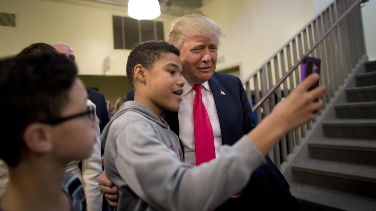 Republican presidential candidate Donald Trump pauses for a selfie after a Sunday service at First Christian Church Sunday, Jan. 31, 2016, in Council Bluffs, Iowa.