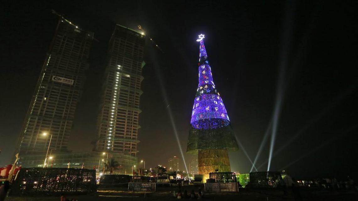 An enormous artificial Christmas tree is seen lit up after its unveiling in Colombo, Sri Lanka, Saturday, Dec. 24, 2016.
