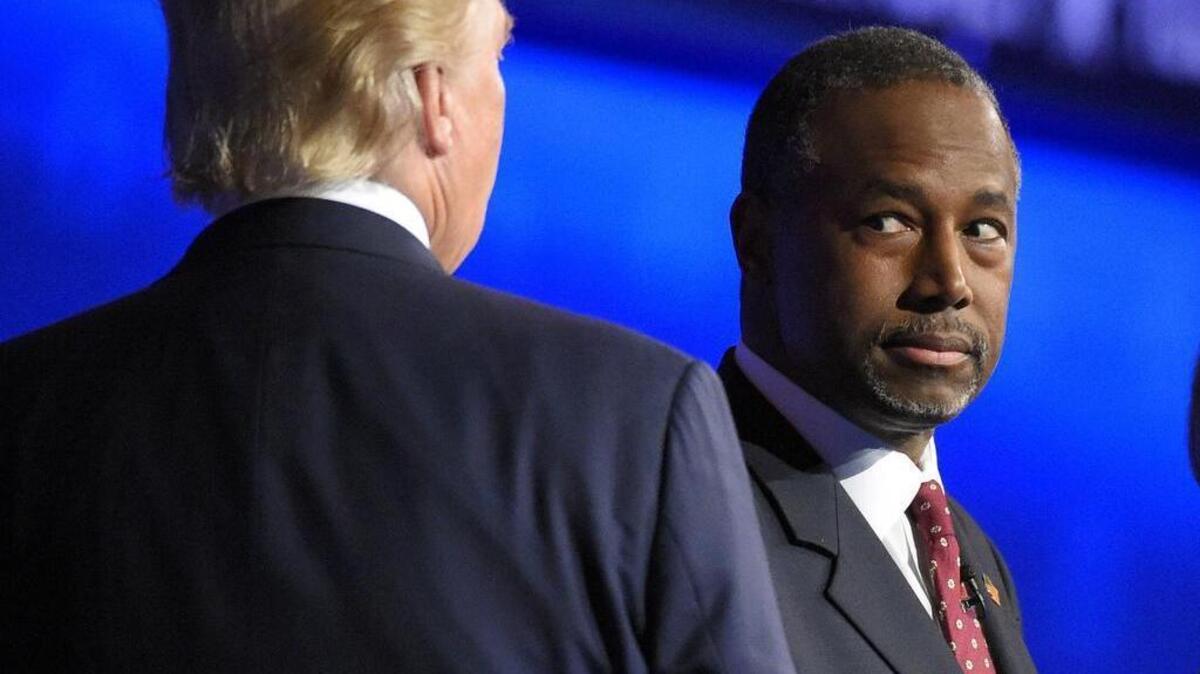 Ben Carson watches as Donald Trump takes the stage during the CNBC Republican presidential debate at the University of Colorado, Wednesday, Oct. 28, 2015, in Boulder, Colo.
